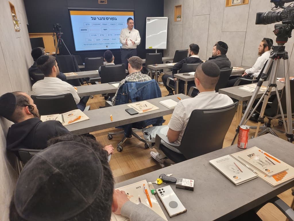 יוסף בן שושן מלמד את קבוצת ההכשרה מול מצגת, המשתתפים יושבים עם חוברות הקורס